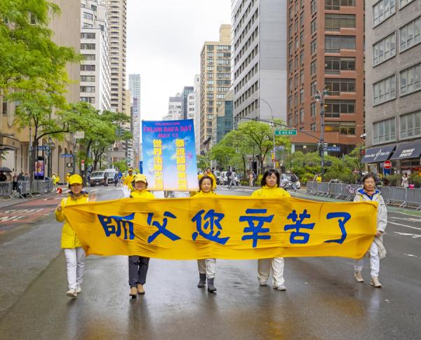 参加游行的法轮功学员拉着横幅 “ 师父您辛苦了 ”， 表达对师父感恩。（摄影：Leo/看中国）